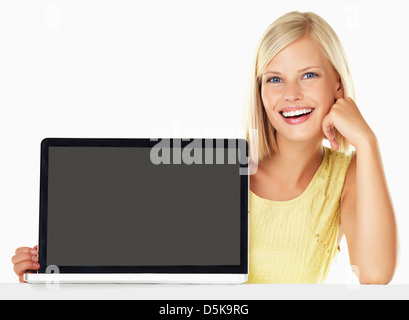 Studio portrait of young woman holding nouvel ordinateur portable Banque D'Images