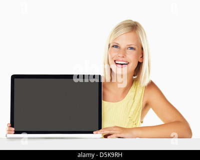 Studio portrait of young woman holding nouvel ordinateur portable Banque D'Images