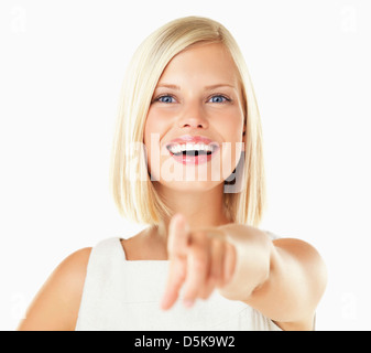 Studio portrait of young woman pointing Banque D'Images