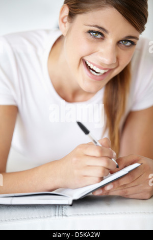 Portrait de jeune femme écrit dans le bloc-notes Banque D'Images