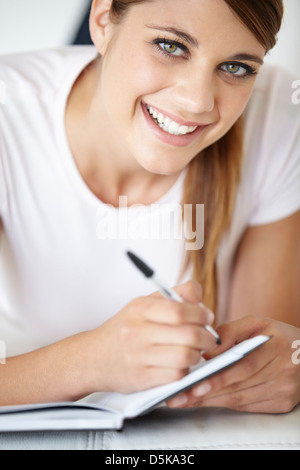 Portrait de jeune femme écrit dans le bloc-notes Banque D'Images