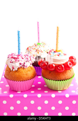Trois petits gâteaux décorés sur une boîte cadeau mouchetures isolated over white Banque D'Images