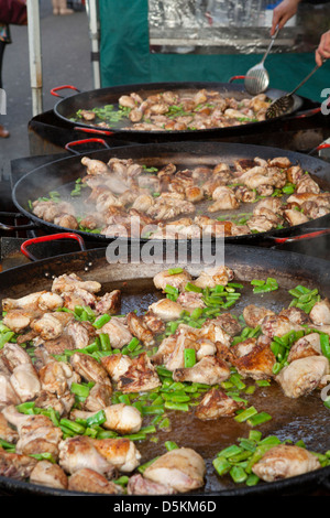 Marché de Portobello Road à Londres. Trois casseroles paella au-dessus de la pleine chaleur d'ingrédients sur une food. Banque D'Images