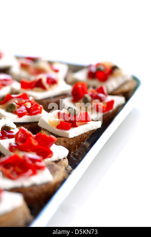 Tranches de pain avec du fromage blanc et du poivre dans un plat argenté prêt à servir pour un événement Banque D'Images