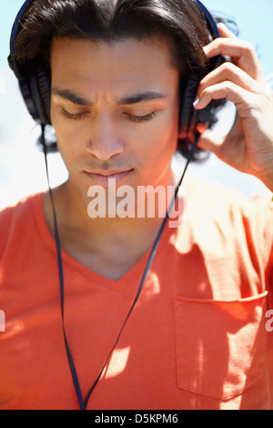 Portrait de jeune homme à écouter de la musique avec des écouteurs Banque D'Images