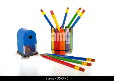 Un collage de couleurs crayons dans une tasse avec un taille-crayon bleu isolé sur fond blanc Banque D'Images