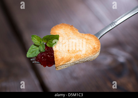 Toast coeur avec la confiture de fraise sur une fourchette Banque D'Images