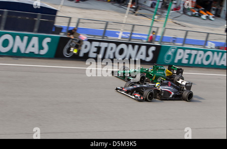 Caterham F1 Team dépassé par l'équipe Ferrari Sauber à la ligne droite principale de Formule 1 GP Petronas Banque D'Images