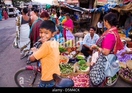 Jeune garçon hindou sur sa bicyclette sourit à la caméra dans le marché en Paud Pune Maharashtra Inde Banque D'Images