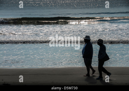 Étape par étape, un couple de personnes âgées de prendre une promenade matinale sur la plage. Banque D'Images