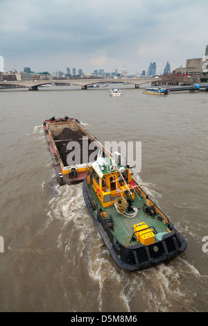 Remorqueur poussant rubbish péniche sur la Tamise à Londres Banque D'Images