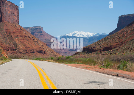 Une route à travers le désert en dehors des formations de roche rouge de Moab, Utah. Banque D'Images