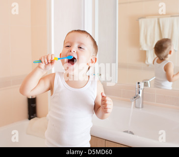 Nettoyer les dents dans la salle de bain garçon Banque D'Images