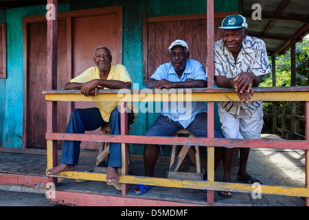 Trois hommes de Vieux Fort, ville St Lucia debout sur le porche d'une maison traditionnelle en bois Banque D'Images