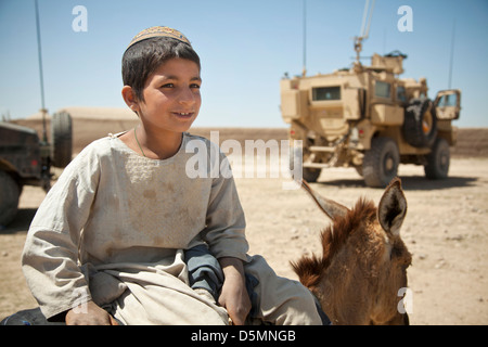 Un jeune garçon Afghan regarde la construction d'un nouveau point de son âne, le 3 avril 2013 dans le district de Spin Boldak, province de Kandahar, Afghanistan. Banque D'Images