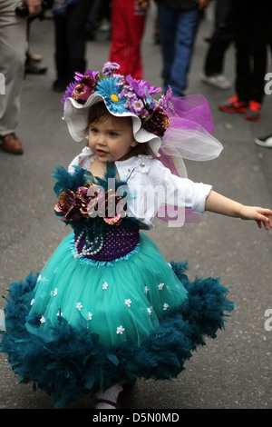 Une petite fille dans une robe et un chapeau fait un spectacle de danse improvisée à la New York City's Easter Parade Banque D'Images