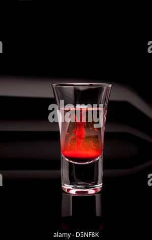 Verre rouge sur fond sombre Banque D'Images