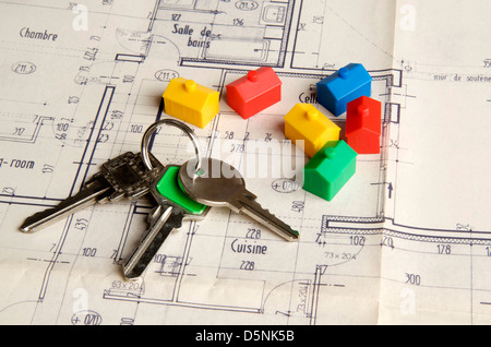 Clés de maison et maisons miniatures sur un plan de construction, pour l'image symbolique du marché immobilier Banque D'Images