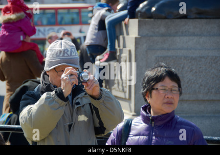 Les touristes de prendre des photos à Trafalgar Square de Londres. Banque D'Images