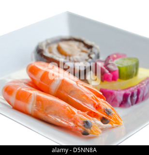 Crevettes cuites avec des légumes marinés et champignons sur plaque blanche, fond blanc Banque D'Images