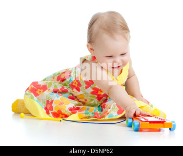 Fille jouant avec des jouets musicaux. Isolé sur fond blanc Banque D'Images