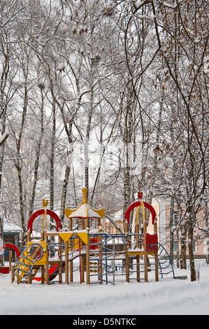 Aire de jeux pour enfants dans le parc déserté couverte de neige Banque D'Images