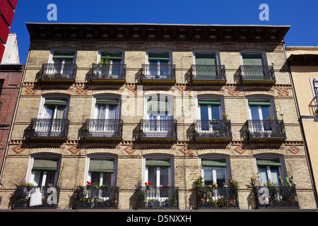 Ancien immeuble d'appartements avec balcon façade de briques à Madrid, Espagne. Banque D'Images