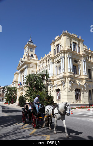 Promenades en calèche avec les touristes en face de l'hôtel de ville de Malaga, Andalousie Espagne Banque D'Images