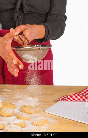 Le sucre en poudre en cours sur des cookies Banque D'Images