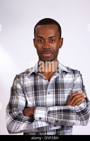 Heureux homme noir dans une chemise à carreaux bleu, regardant la caméra avec un sourire amical, agréable Banque D'Images
