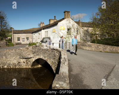 Royaume-uni, Angleterre, dans le Yorkshire, Malham, marcheurs traversant pont de pierre de l'ancienne rivière Aire Banque D'Images