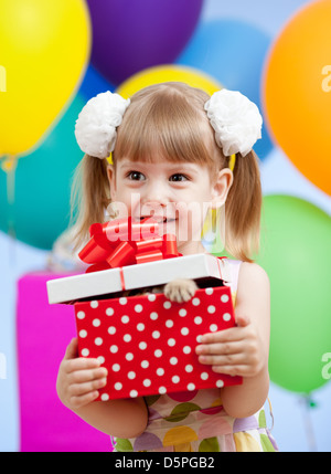 Fille mignonne avec des ballons colorés et cadeaux Banque D'Images