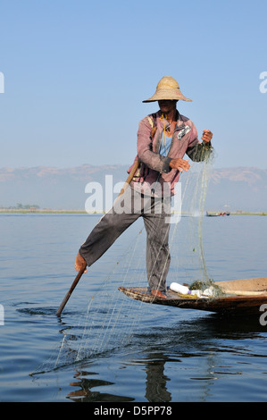 Pêcheur avec son bateau aviron net avec une jambe, au Lac Inle, l'État de Shan, Myanmar, en Asie du sud-est Banque D'Images