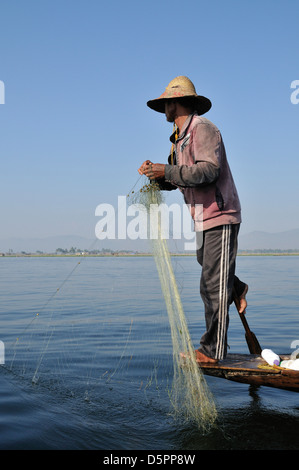 Pêcheur avec son bateau aviron net avec une jambe, au Lac Inle, l'État de Shan, Myanmar, en Asie du sud-est Banque D'Images