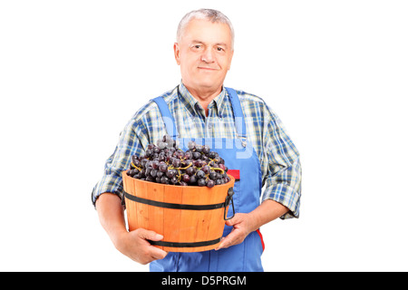 Un vigneron tenant un seau de raisins isolé sur fond blanc Banque D'Images