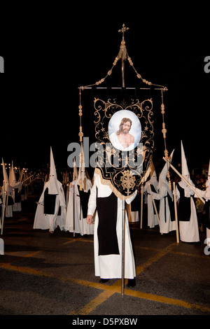 Nazarene habillé en blanc les tuniques, masques et cagoules lors de la Semana Santa ou des processions de la Semaine Sainte en Andalousie, Espagne Banque D'Images