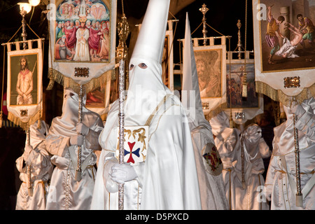 Nazarene habillé en blanc les tuniques, masques et cagoules lors de la Semana Santa ou des processions de la Semaine Sainte en Andalousie, Espagne Banque D'Images