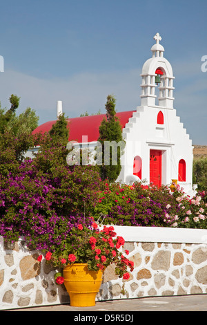 Petite chapelle grecque, clocher et jardin avec bougainvilliers et géraniums dans la campagne sur l'île de Mykonos, Grèce Banque D'Images