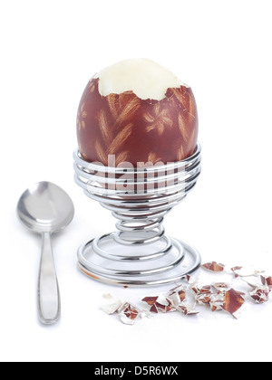 Oeufs à la coque avec des oeufs de Pâques ornement-shell dans un stand en spirale avec cuillère prêt pour le petit-déjeuner tourné sur fond blanc Banque D'Images