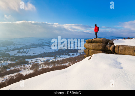 Randonneur dans les pics couverts de neige sur le bord Curbar Parc national de Peak District Derbyshire, Angleterre GO UK EU Europe Banque D'Images