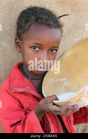 Girl Boissons Lait de vache à partir d'une calebasse, Burkina Faso Banque D'Images