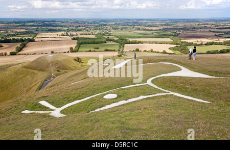 L'Uffington White Horse, un personnage sculpté préhistorique à la craie sur un escarpement de la Berkshire Downs donnant sur la Colline du Dragon ci-dessous. Banque D'Images