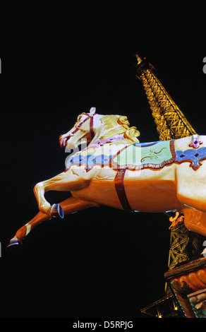 Carousel horse éclairés la nuit avec en arrière-plan la Tour Eiffel Paris France Banque D'Images