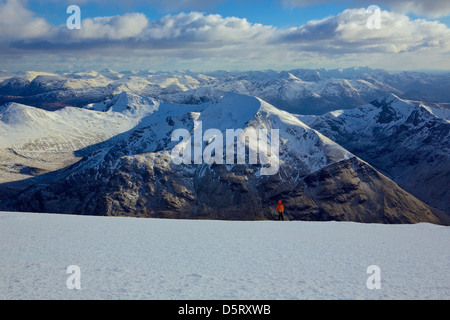 La vue depuis le sommet du Ben Nevis dans des conditions de neige et d'une bonne visibilité. Un grimpeur peut être vu dans la distance Banque D'Images