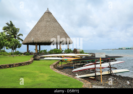Kayak de racks de stockage et gazebo au toit de chaume le long de la rive du Jardins de Paofai, Papeete, Tahiti. Banque D'Images
