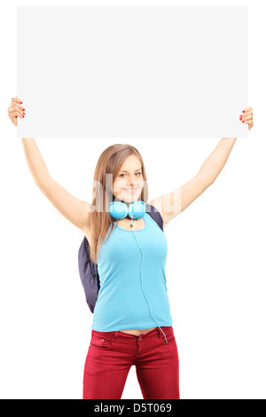 Belle jeune femme avec sac à dos pour l'école tenant un panneau blanc au-dessus de sa tête isolé sur fond blanc Banque D'Images