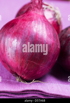 Close up oignons rouges sur le tapis de table violet Banque D'Images