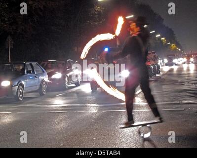 Un homme jongle avec le feu sur la rue du 17 juin avant qu'une colonne de la police d'attente à Berlin, Allemagne, 16 novembre 2012. Artistes artistique présentent leurs astuces à tous les feux de circulation au-dessus de Berlin pour le changement. Photo : Franz-Peter Tschauner Banque D'Images