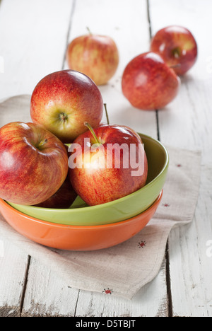 Plusieurs de pommes rouges dans les plaques de couleur blanche sur la table de cuisine Banque D'Images