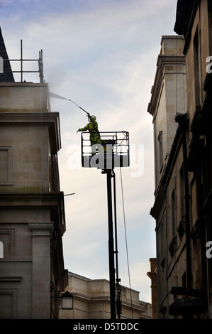 Un constructeur dans une grue de pulvériser la façade de la baignoire centre commercial Southgate, Somerset UK Banque D'Images